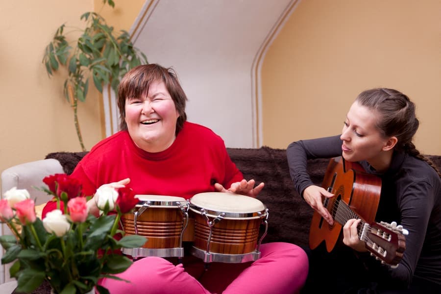 A person we support enjoying a music activity with a carer